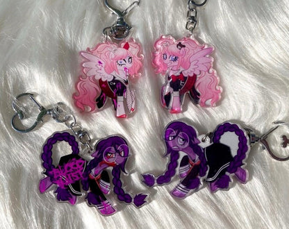 Four acrylic keychains featuring anime-style pony characters, displayed on a white faux fur background. The set includes two pink-haired keychains and two purple-haired keychains, each with a silver metal keyring and clasp.